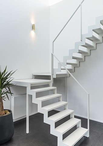 Weiße Treppe mit moderner Up-and-Down-Wandlampe